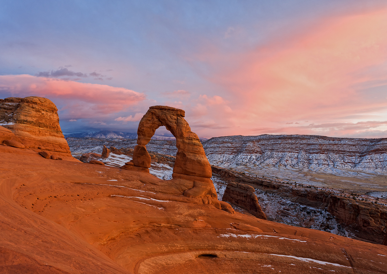 A colorful winter sunset ends a beautiful day at Delicate Arch in Arches National Park, Utah.